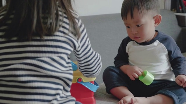 亚洲兄弟姐妹在家里玩玩具。