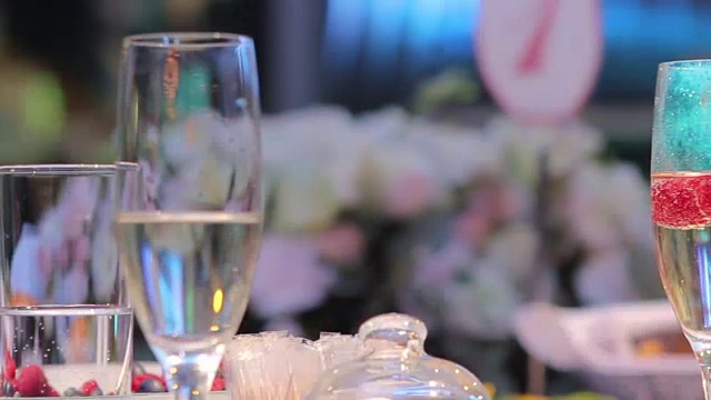 详情图-装饰蜡烛在餐桌上，眼镜和圣诞蜡烛在桌子上，白色蜡烛与玻璃烛台，蜡烛与玻璃烛台，餐厅，室内，特写