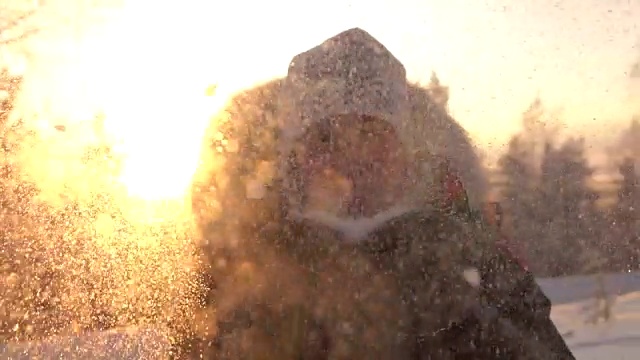 详情图-慢镜头:在神奇的冬天，年轻女子在夕阳下吹着雪花