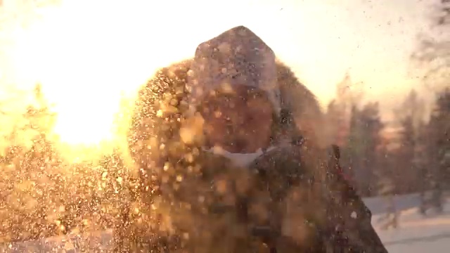 详情图-慢镜头:在神奇的冬天，年轻女子在夕阳下吹着雪花