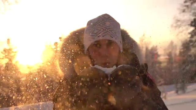 详情图-慢镜头:在神奇的冬天，年轻女子在夕阳下吹着雪花