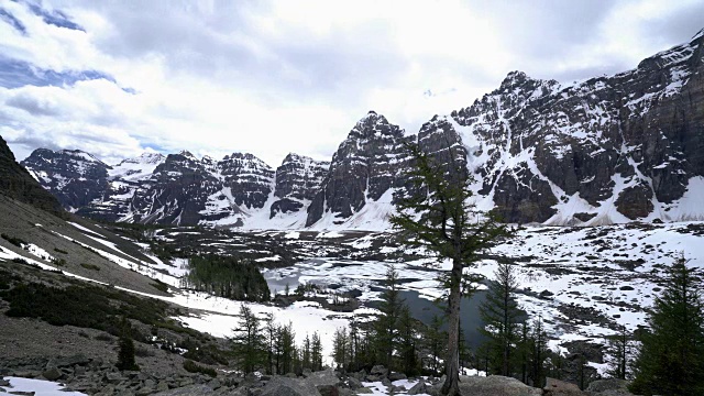 在加拿大落基山脉的中心地带，云层在高山冰冻的湖面上移动。