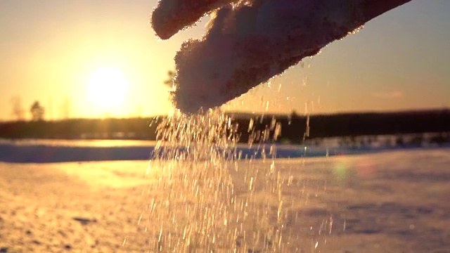 慢镜头，宏:湿润的雪花在手中融化，落在雪地上