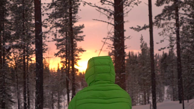 慢镜头:一个面目全非的人在金色的夕阳下向空中抛雪