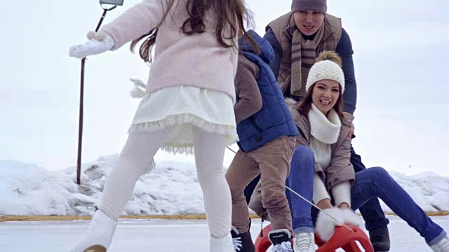 孩子们拉着妈妈在雪橇上