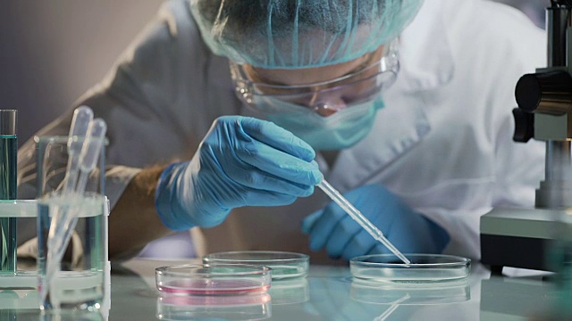 科学家小心翼翼地将成熟的细胞移植到另一个平板上，进行研究