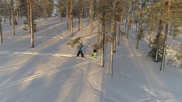 在寒冷的冬天的早晨，男男女女穿着雪鞋走在刚下过的雪地上