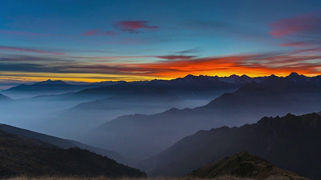 日落时阿尔卑斯山的全景，令人惊叹的彩色天空