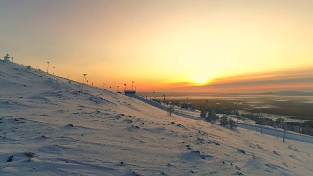 空中活跃的女人穿着雪鞋在雪坡上扬起双臂