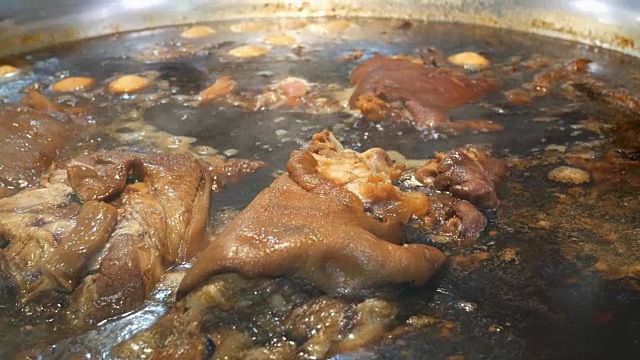 猪腿用热汤炖在一个大锅里，配上一束香草