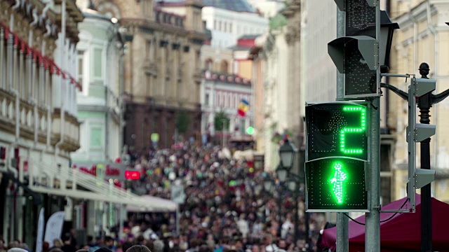 Сrowd匿名的人在城市的主要街道上像大蚁冢靠近行人十字路口的红绿灯背景与行人标志。概念现代城市景观城市生活。市中心步行区的购物者。模糊的行人交通