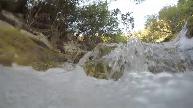 河水对着相机流淌，河水中有小瀑布