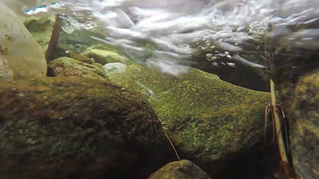 在一条河的里面，河水在用力地冲击着摄像机