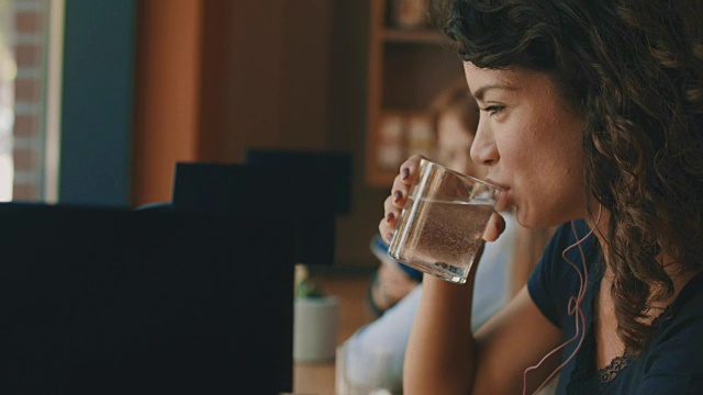 年轻女子正在喝一杯水