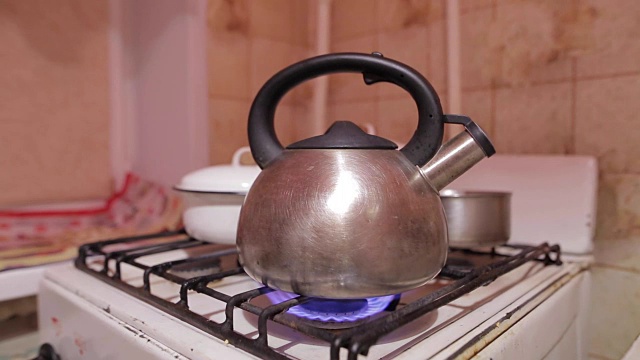 天然气火焰水壶的特写镜头。晚上喝茶。茶壶和沸水