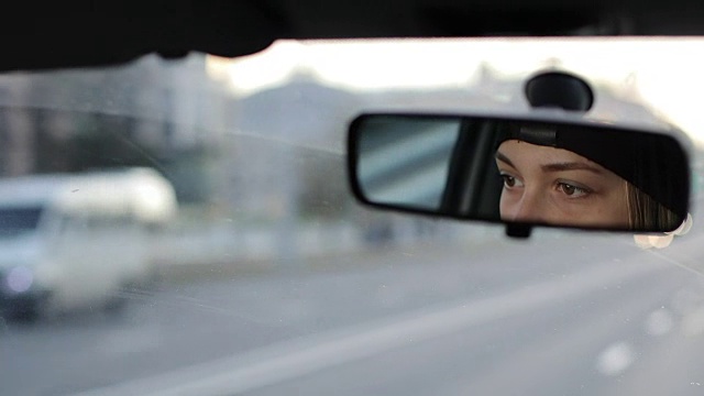 詳情圖-那個(gè)女孩正在開(kāi)車。從汽車后視鏡里可以看到女性的眼睛。