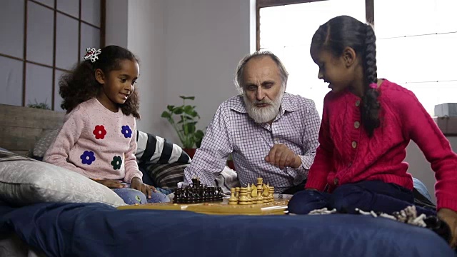 爷爷在家教孙子孙女们下棋