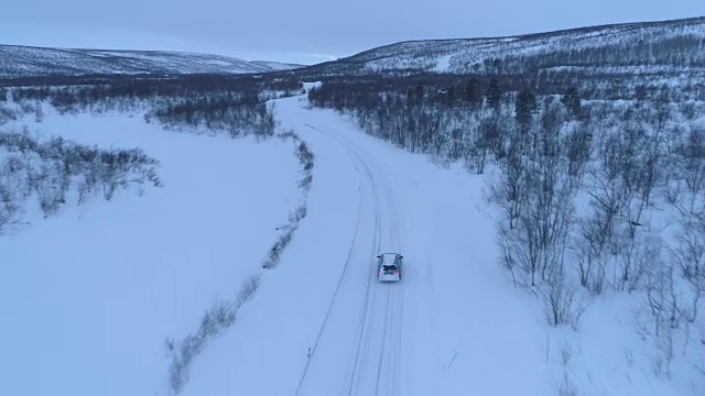 空中汽车在雪道上行驶，穿过令人惊叹的山区冬季景观