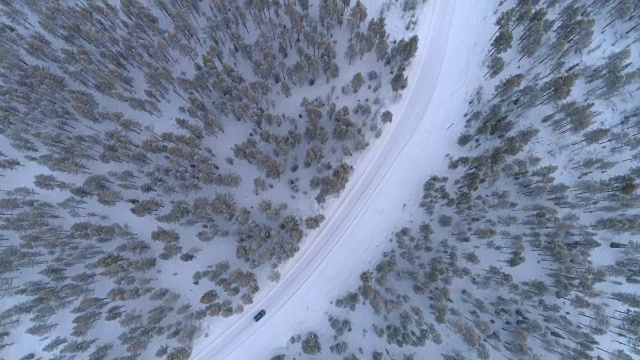 空中俯瞰:汽车在冬日仙境的雪道上行驶