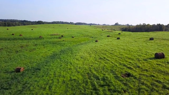 一捆捆干草躺在乡间的草地上。航空摄影测量