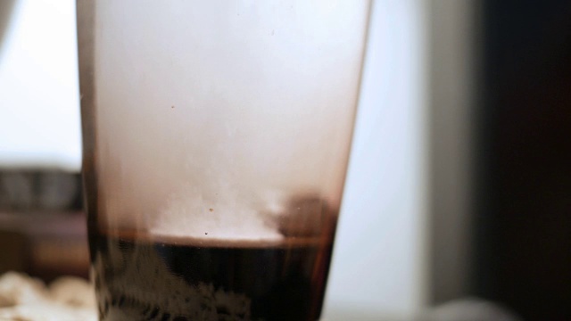 溶解药片滴入床头柜上的水杯中