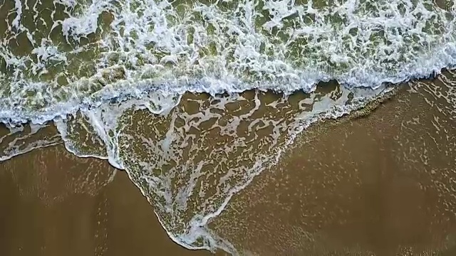 无人机拍摄的海浪到达海岸的画面。航空摄影测量。慢动作