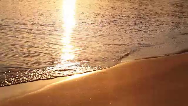 海浪在热带的海滩在黎明，早晨在海上，日出在海滩上，橙色的阳光，海滩和海日落，海日落，黎明，日落，太阳反射在水面上