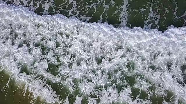 从顶部观看浪花在水面上创造了一种独特的图案。航空摄影测量。慢动作
