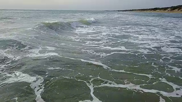 海浪的观点从近距离，然后从高度上外向进入地平线的大海。航空摄影测量。慢动作