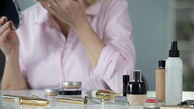 女人用抗衰老化妆品来护理皱纹皮肤，渴望变得美丽