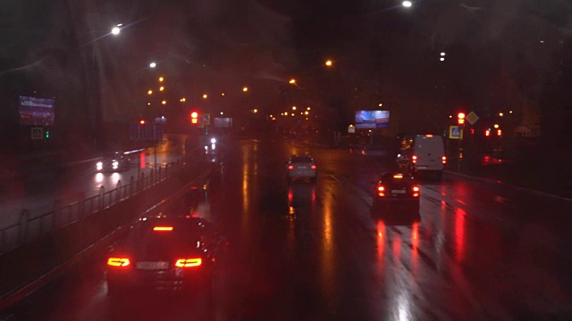 夜晚的道路。从赛道上的车里射击。汽车前进。下雨了，雨滴落在左边的玻璃上。从一辆双层巴士上射击。4л