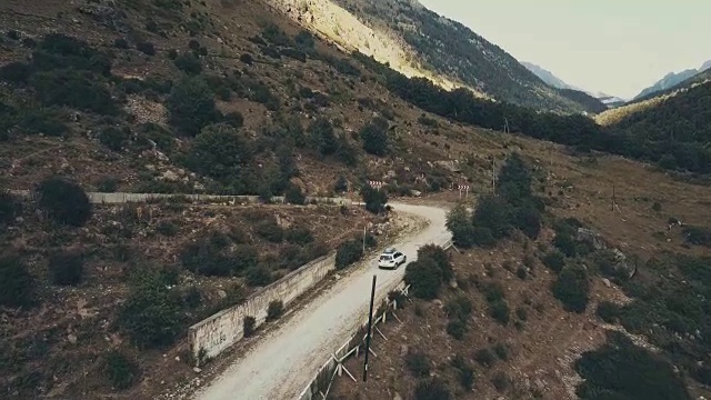 俯视图汽车吉普车沿着蜿蜒的山路在暑假