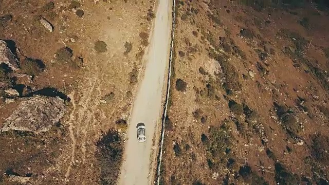 从上面看，白色汽车在蜿蜒的山路上行驶