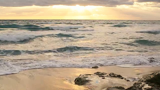日出时的海滩波浪