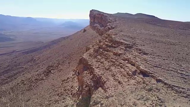 一群在沙漠岩石上爬山的山羊
