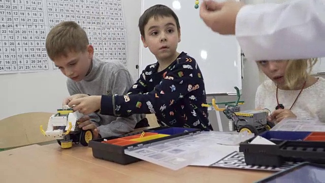 可爱的孩子们在小学里建造机动机器人