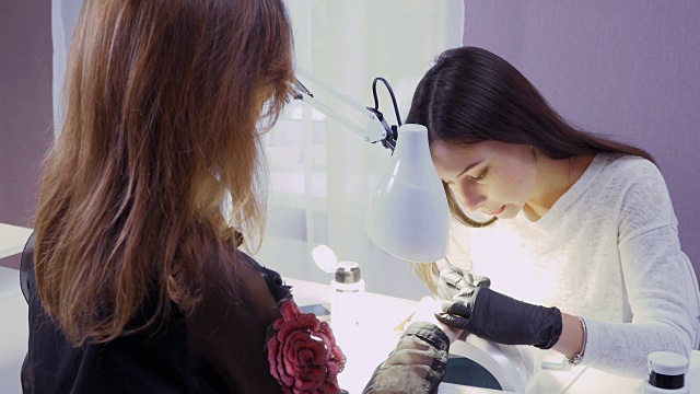 美甲师为年轻女性做美甲
