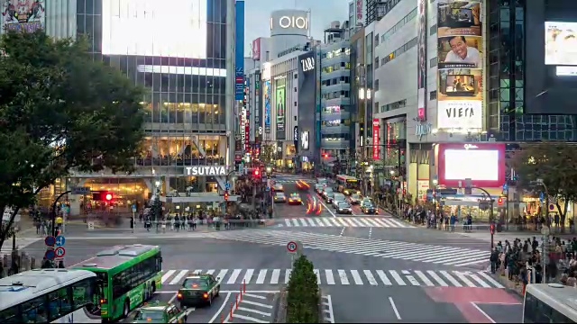 在涉谷十字路口广场，行人在拥挤的交通中走过