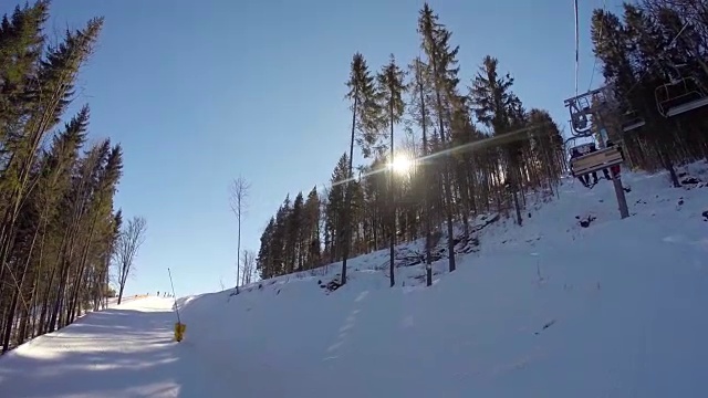 滑雪缆车把人们抬上山。滑雪者从多雪的山上下来。人们在滑雪，高山上的云杉，阳光灿烂的日子