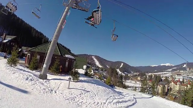 滑雪缆车把人们抬上山。滑雪者从多雪的山上下来。人们在滑雪，高山上的云杉，阳光灿烂的日子