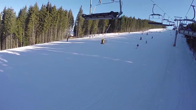 滑雪缆车把人们抬上山。滑雪者从多雪的山上下来。人们在滑雪，高山上的云杉，阳光灿烂的日子