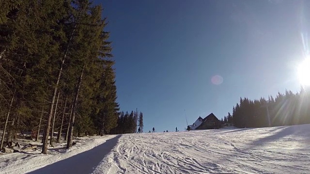 滑雪者来自雪山，滑雪缆车载着人们上山，滑雪者从雪山上下来，人们在滑雪，高高的云杉在山坡上，阳光灿烂的日子