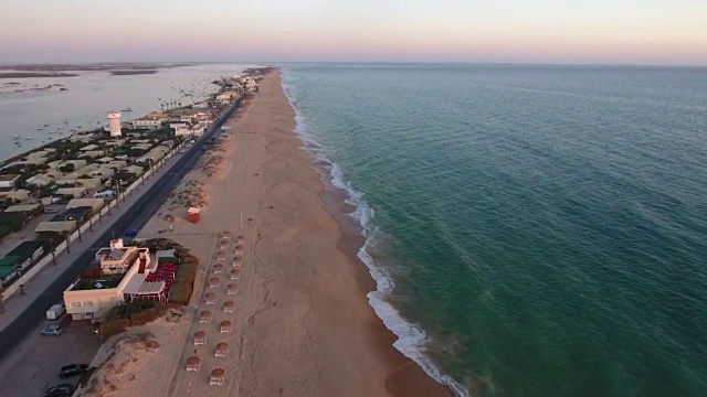 在日落时飞过法罗海滩(普拉亚德法罗)，葡萄牙阿尔加维