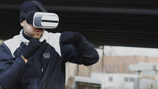 詳情圖-慢動作的人拳擊手在VR,360頭盔訓練出拳在虛擬現(xiàn)實戰(zhàn)斗戶外在冬天