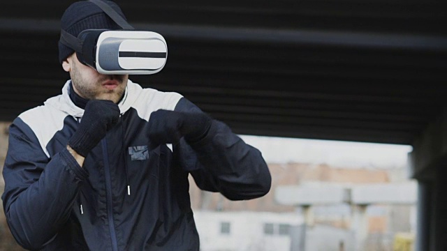 詳情圖-慢動作的人拳擊手在VR,360頭盔訓練出拳在虛擬現(xiàn)實戰(zhàn)斗戶外在冬天