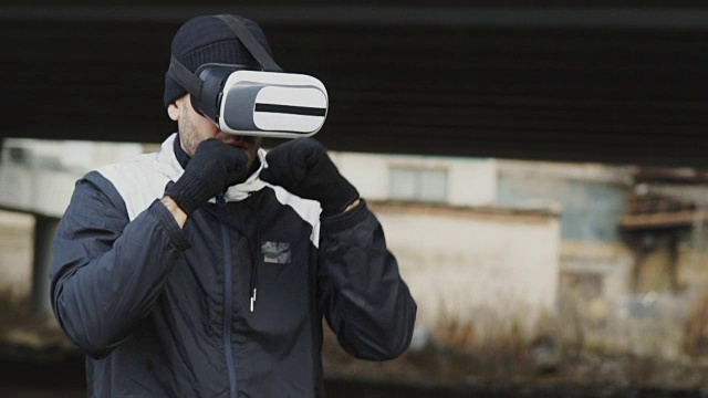 詳情圖-慢動作的人拳擊手在VR,360頭盔訓練出拳在虛擬現(xiàn)實戰(zhàn)斗戶外在冬天
