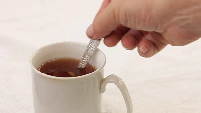 倒入一杯茶用茶匙加糖