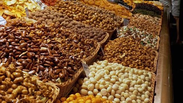 大柜台的干果，坚果和糖果在一个市场在La Boqueria。巴塞罗那。西班牙