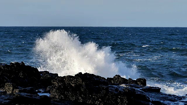 慢镜头的巨浪冲击着冰岛的海岸岩石