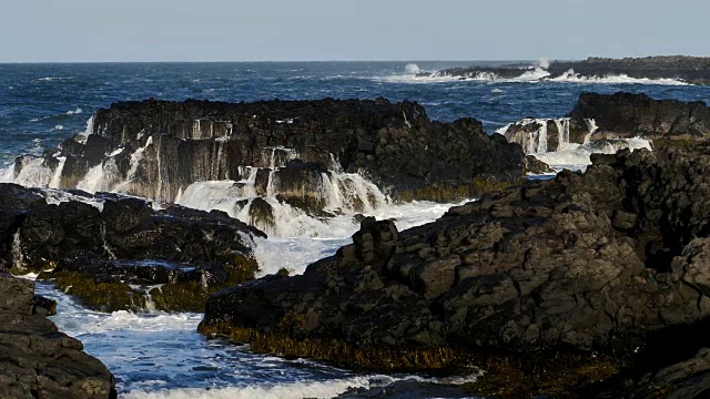 慢镜头，巨大的海浪冲击着岩石嶙峋的冰岛海岸线